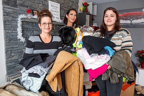 MIKE DEAL / WINNIPEG FREE PRESS
Theresa Chanowski (left), her daughter Katie Titanich (right) and best friend Jessica Yery (centre) with clothing and winter jackets that have been donated.
Theresa Chanowski, her daughter Katie Titanich and best friend Jessica Yery are distributing hot meals and winter wear to people on the streets in Winnipeg's inner city. They are collecting donations from family and friends.
See Tyler story
211201 - Wednesday, December 01, 2021.