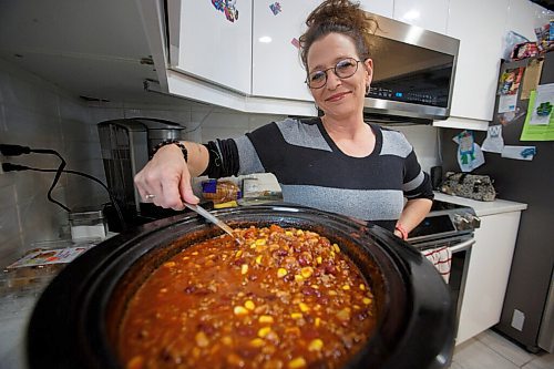 MIKE DEAL / WINNIPEG FREE PRESS
Theresa Chanowski with a fresh pot of chili almost ready to be distributed.
Theresa Chanowski, her daughter Katie Titanich and best friend Jessica Yery are distributing hot meals and winter wear to people on the streets in Winnipeg's inner city. They are collecting donations from family and friends.
See Tyler story
211201 - Wednesday, December 01, 2021.