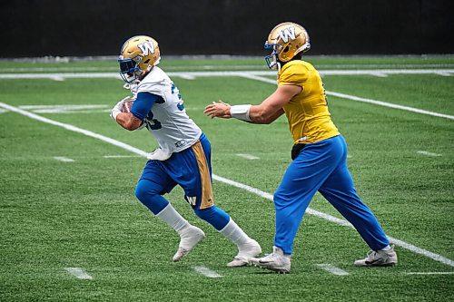 MIKE DEAL / WINNIPEG FREE PRESS
Winnipeg Blue Bombers Andrew Harris (33) is handed the ball from quarterback Zach Collaros (8) during practice at IG Field Wednesday morning.
211201 - Wednesday, December 01, 2021.