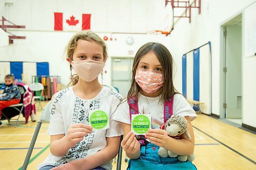 Mike Sudoma / Winnipeg Free Press
Friends Chloe Silvari (left) and Ella Claire (right) show off their Im Covid 19 Vaccinated stickers after receiving their Covid 19 Vaccination in the gym of Governor Semple School Friday afternoon
December 3, 2021