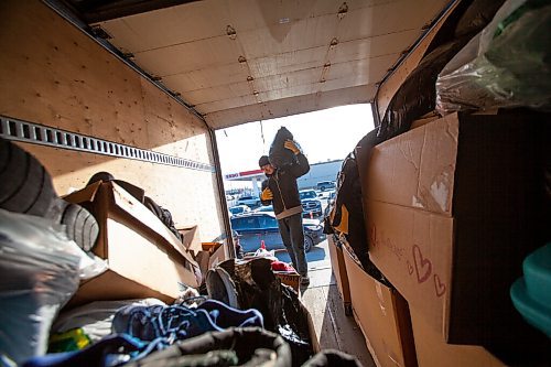 Daniel Crump / Winnipeg Free Press. Kyle Beaulieu helps load donations into the back of a truck during the fifth annual Fill the Freightliner donation drive at Boston Pizza on Kenaston, Saturday afternoon. December 4, 2021.