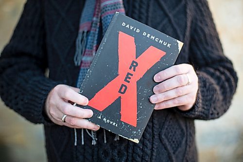 Daniel Crump / Winnipeg Free Press. David Demchuk holds a copy of his book Red X, which is a gay horror novel about an evil entity stalking the gay community in Toronto over a period of centuries. December 4, 2021.