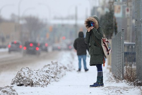 SHANNON VANRAES / WINNIPEG FREE PRESS
A masked person pulls their hood around their face while waiting for a transit bus on St. Marys Ave. December 5, 2021.