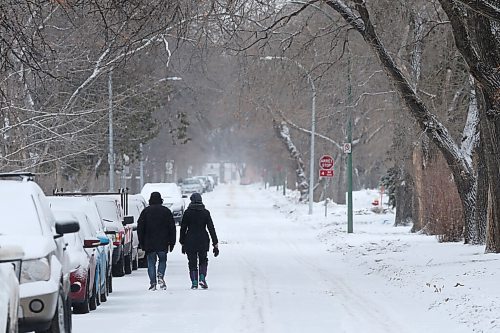 SHANNON VANRAES / WINNIPEG FREE PRESS
Two figures walk downs a snowy residential street in St. Boniface on December 5, 2021.