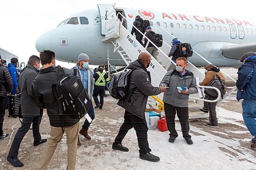 MIKE DEAL / WINNIPEG FREE PRESS
Winnipeg Blue Bombers are handed masks as they board their plane to Hamilton for the 108th Grey Cup Tuesday afternoon.
211207 - Tuesday, December 07, 2021.