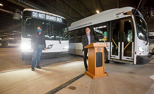 MIKE DEAL / WINNIPEG FREE PRESS
Winnipeg City councillor, Matt Allard (left), Chairperson of the Standing Policy Committee on Infrastructure, Renewal and Public Works and Greg Ewankiw (right), Director of Winnipeg Transit unveil the new emergency signals on transit buses at a Winnipeg Transit garage, 421 Osborne Street, Thursday afternoon.
Transit drivers have long complained that theres a lack of security on buses, with frequent assaults against drivers, and have welcomed this move. 
Winnipeg Transits new emergency signal system will be fully operational on all Winnipeg Transit buses by December 15, 2021.
The new system will allow operators to alert members of the public outside the bus and the Transit Control Centre at the same time, that emergency responders are needed. When operators enable the signal, exterior bus signs will read Emergency Call 911 and Do Not Board Bus.
211209 - Thursday, December 09, 2021.