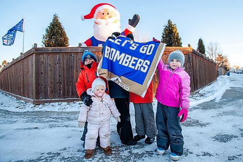 Daniel Crump / Winnipeg Free Press. River Wallace, Abigail Thurston, Tate Luindquist, Brooks Lundquist and Paeton Thurston visit Santa every year at his spot near Warde Avenue and Paddington Road. This year is a little different as Santa is dressed in a Winnipeg Blue Bombers jersey to cheer on the team as they take on the Hamilton Tiger Cats in the Grey Cup on Sunday. December 10, 2021.