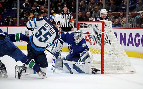 Winnipeg Jets' Mark Scheifele (55) is tripped as he tries to shoot on Vancouver Canucks' goaltender Thatcher Demko (35) during second period NHL hockey action in Vancouver, BC, Friday, December 10, 2021. (TREVOR HAGAN / WINNIPEG FREE PRESS)