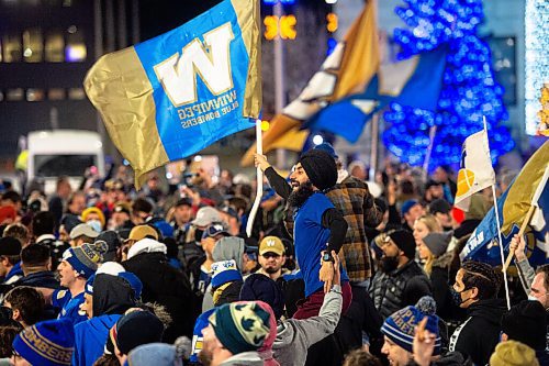 Mike Sudoma / Winnipeg Free Press
A Blue Bombers fan flies a Winnipeg Blue Bombers flag while on top the shoulders of another fan Sunday evening as hundreds of fans at Portage and Main to celebrate the Bombers 3rd consecutive year as Grey Cup Champions Sunday evening
December 12, 2021