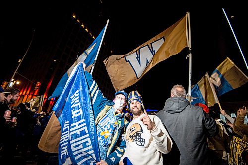 Mike Sudoma / Winnipeg Free Press
(Left to right) Mackinley Hall and Ethan Nagler hold up a Blue Bombers banner as Winnipeg Blue Bombers fans young and old celebrate the Bombers overtime win over the Hamilton Tiger Cats at Portage and Main Sunday evening
December 12, 2021
