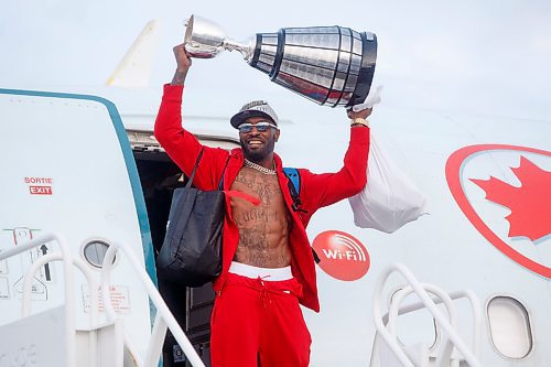 MIKE DEAL / WINNIPEG FREE PRESS
Winnipeg Blue Bombers and Grey Cup Champion Willie Jefferson carries the trophy off the plane as the team arrives home from Hamilton Monday afternoon.
211213 - Monday, December 13, 2021.