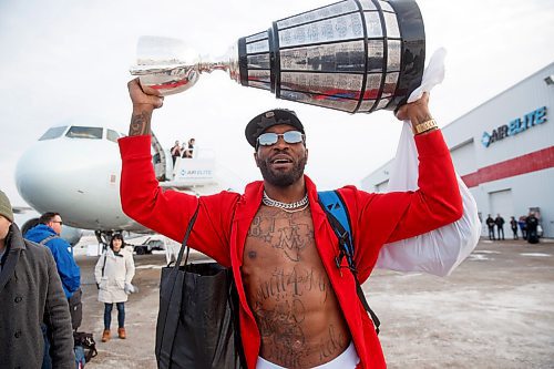 MIKE DEAL / WINNIPEG FREE PRESS
Winnipeg Blue Bombers and Grey Cup Champion Willie Jefferson carries the trophy off the plane as the team arrives home from Hamilton Monday afternoon.
211213 - Monday, December 13, 2021.