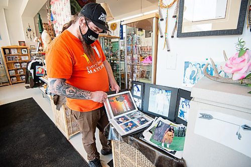 Mike Sudoma / Winnipeg Free Press
Keith Proulx, Owner of Cree Ations and Artist Showcase, looks through a photo book from different fashion shows and photoshoots that Cree Ations clothing were featured in through the years.
December 13, 2021