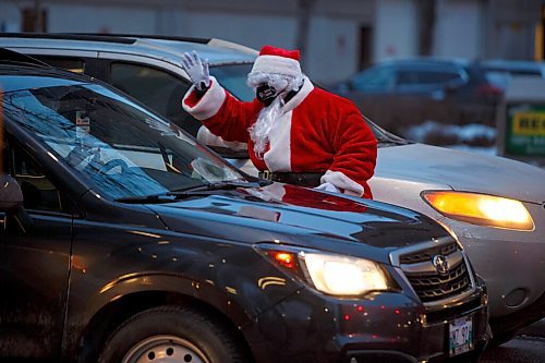 MIKE DEAL / WINNIPEG FREE PRESS
Santa is helping the Downtown Winnipeg BIZ launch its brand-new Downtown Winnipeg Gift Card program by handing out gift cards to passersby at Donald and Broadway early Friday morning. The first program of its kind for Winnipeg is aimed to help downtown businesses recover. 
211217 - Friday, December 17, 2021.