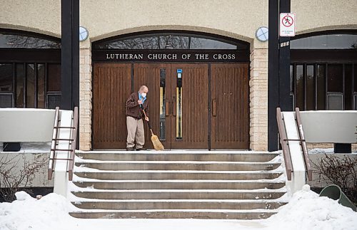 Mike Sudoma / Winnipeg Free Press
A man sweeps the snow off of the steps of the Evangelical Lutheran Church of the Cross as attendees are about to be let out Sunday morning
December 19, 2021