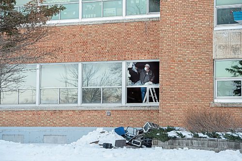 Mike Sudoma / Winnipeg Free Press
A worker pulls glass out of a broken window on the first floor of St James Collegiate Sunday afternoon after a fire broke out Sunday morning. 
December 19, 2021