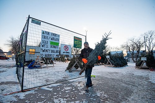 Mike Sudoma / Winnipeg Free Press
Ches Szylkin picks up a Christmas tree fro his family at the 67th Winnipeg Scout Group Christmas Tree Lot held at the Corydon Community Centre Monday evening. December 20, 2021