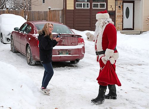 JASON HALSTEAD / WINNIPEG FREE PRESS

A neighbour snaps a photo during a surprise visit from Santa Claus (a.k.a. Dennis Radlinsky) on her Charleswood street. (Reporter: Malak Abas; family didn't want last name used)