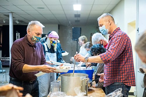 MIKAELA MACKENZIE / WINNIPEG FREE PRESS

Kurt Hollander (right) ladles gravy into a hot Christmas meal that George Hollander packs up at the Mission Baptist Church in Winnipeg on Saturday, Dec. 25, 2021.  For Malak story.
Winnipeg Free Press 2021.