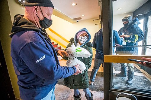 MIKAELA MACKENZIE / WINNIPEG FREE PRESS

Volunteer John Sawatzky (left) hands Natalie Kirton two hot Christmas meals at the Mission Baptist Church in Winnipeg on Saturday, Dec. 25, 2021.  For Malak story.
Winnipeg Free Press 2021.