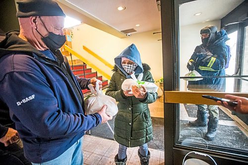 MIKAELA MACKENZIE / WINNIPEG FREE PRESS

Volunteer John Sawatzky (left) hands Natalie Kirton two hot Christmas meals at the Mission Baptist Church in Winnipeg on Saturday, Dec. 25, 2021.  For Malak story.
Winnipeg Free Press 2021.