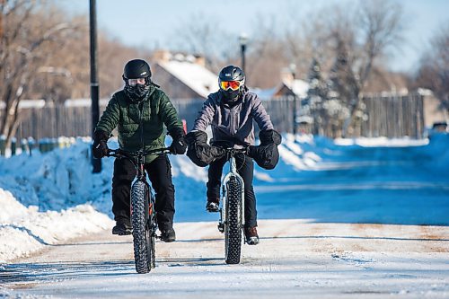 MIKAELA MACKENZIE / WINNIPEG FREE PRESS

Jerrie Quebrado (left) and Eddie Revilla brave the frigid temperatures by fat-biking through St. Boniface in Winnipeg on Friday, Dec. 31, 2021. Standup.
Winnipeg Free Press 2021.