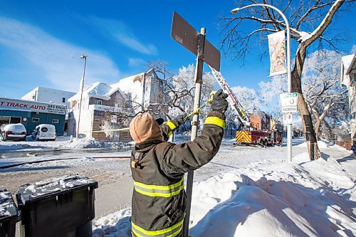 Daniel Crump / Winnipeg Free Press. A firefighter puts up safety flagging at the site of a New Years Eve fire that has destroyed an apartment building near Sherbrook Street and Ellice Avenue. January 1, 2022.