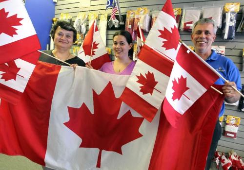 BORIS.MINKEVICH@FREEPRESS.MB.CA  100628 BORIS MINKEVICH / WINNIPEG FREE PRESS The Flag Shop. Canada Day. l-r Magda, Samantha, and Guy Gauthier pose for a photo with some of the Canada flags in the shop.