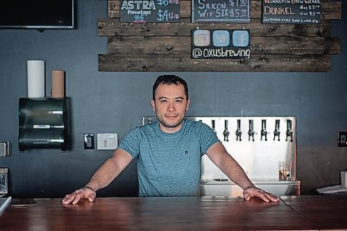 Canstar Community News Sean Shoyoqubov, owner of Oxus Brewing Company, stands in the taproom attached to his brewing facility.