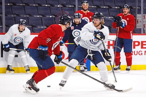 MIKE DEAL / WINNIPEG FREE PRESS
Winnipeg Jets' Kyle Connor (81) makes a backhanded behind the back pass while evading Neal Pionk (4) during practice at Canada Life Centre Tuesday morning.
220111 - Tuesday, January 11, 2022.