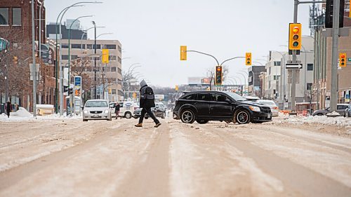 Mike Sudoma / Winnipeg Free Press
A driver and a pedestrian crosses Portage Ave at Sherbrooke Star they makethier way over the massive ruts of snow and ice on Portage Ave at Furby St Tuesday afternoon
January 11, 2022