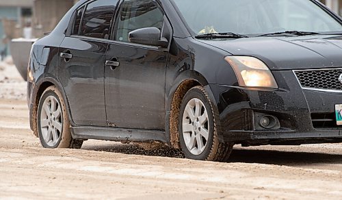 Mike Sudoma / Winnipeg Free Press
A car makes its way over the massive ruts of snow and ice on Portage Ave at Furby St Tuesday afternoon
January 11, 2022