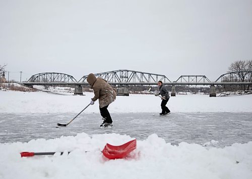 JESSICA LEE / WINNIPEG FREE PRESS

Two teenagers play hockey on the ice on Red River on January 11, 2022.







