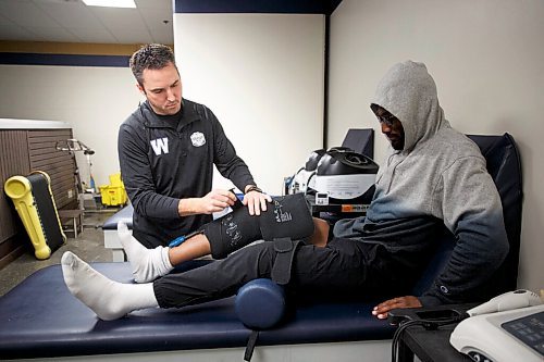 MIKE DEAL / WINNIPEG FREE PRESS
Winnipeg Blue Bombers Director of Health and Performance as well as Head Athletic Therapist, Alain Couture, puts a cold pressure wrap on defensive back Brandon Alexander who made a visit for some physical therapy.
Alain has been with the team for 18 seasons and thought he had seen it all. But coming off a cancelled season and playing in the middle of a pandemic was unique to anything Couture had experienced before. 
See Taylor Allen story
220118 - Tuesday, January 18, 2022.