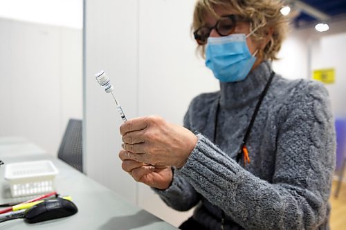 MIKE DEAL / WINNIPEG FREE PRESS
Registered nurse, Irene Paré, loads her needles with the Pfizer BioNTech vaccine at her station before the start of her day Friday morning.
Ma Mawi Wi Chi Itata Centre vaccine clinic at 363 McGregor Street, brings in a lot of community support and Indigenous tradition including a morning smudge of the vaccines. The atmosphere of togetherness and one-on-one support has helped many in the area who may be wary of getting the vaccine.
See Melissa Martin story
220121 - Friday, January 21, 2022.