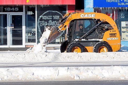 MIKE DEAL / WINNIPEG FREE PRESS
A small frontend loader clears snow on the sidewalk along Portage Avenue Monday afternoon.
220124 - Monday, January 24, 2022.