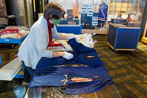 MIKE DEAL / WINNIPEG FREE PRESS
Andrea Reichert, curator at the Manitoba Sports Hall of Fame & Museum, with speed skating outfits that were worn by Donna Keating in 1972 and Sylvia Burka in 1976 (foreground).
See Brenda Suderman story
220125 - Tuesday, January 25, 2022.