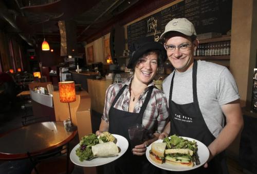MIKE.DEAL@FREEPRESS.MB.CA 100707 - Wednesday, July 07, 2010 -  Restaurant review The Fyxx coffee shop on Arthur Street in the Exchange. Baristas Rachel Gerson and Chris Campbell with a What's Gotten India wrap and a Tre Cheesi sandwich. MIKE DEAL / WINNIPEG FREE PRESS