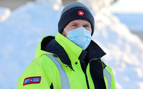 RUTH BONNEVILLE / WINNIPEG FREE PRESS

Local - letter carrier 

Letter-carrier Corey Gallagher was sent home from his work at Canada Post because his boss said he couldnt wear a medical grade respirator, similar to an N95, to work.

Gallagher wears a white 95PFE-L3 with a  blue provided "Level 2" mask on top in photo. 

Jan 28th,  2022