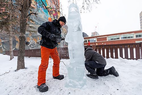 Daniel Crump / Winnipeg Free Press. Daniel Friesen and Helen Friesen carve a goldeye out of a block of ice on Broadway near Gary Street. The ice is sourced from the Red River and the project is part of an exhibit called Winter Wanderland, a joint venture between Downtown Winnipeg BIZ and Sputnik Architecture. January 29, 2022.
