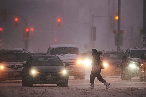 MIKE DEAL / WINNIPEG FREE PRESS
A pedestrian crosses Memorial Blvd at Portage Avenue early Tuesday morning during blizzard conditions.
220201 - Tuesday, February 01, 2022.