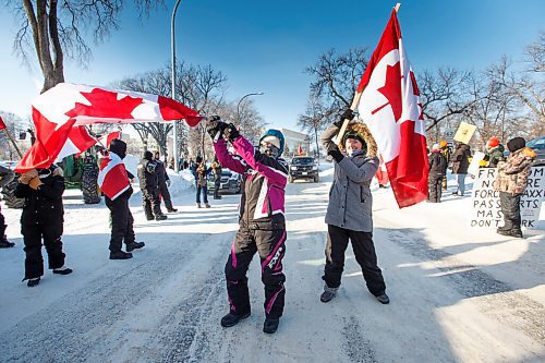 MIKE DEAL / WINNIPEG FREE PRESS
Annie Wiebe (left) and her niece, Claudia (right) wave Canadian flags at supporters as they drive by on Broadway during the Anti-Vaccine Mandate protest Friday morning.
Protesters block the entrance to the Manitoba Legislative building on Broadway and have parked their trucks along Memorial early Friday morning.
220204 - Friday, February 04, 2022.