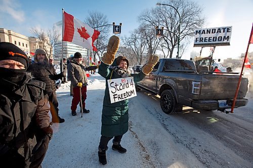 MIKE DEAL / WINNIPEG FREE PRESS
Carol Rybczuk waves at supporters as they drive by on Broadway during the Anti-Vaccine Mandate protest Friday morning.
Protesters block the entrance to the Manitoba Legislative building on Broadway and have parked their trucks along Memorial early Friday morning.
220204 - Friday, February 04, 2022.