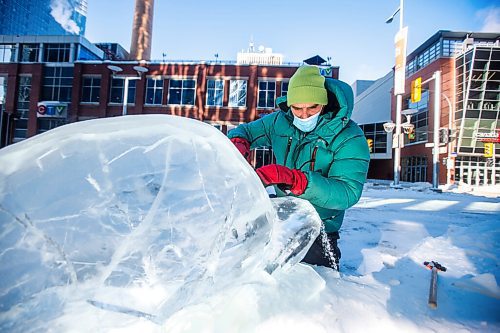 MIKAELA MACKENZIE / WINNIPEG FREE PRESS

Peter Hargraves works on the finishing touches of an ice sculpture of belugas at True North Square in Winnipeg on Friday, Feb. 4, 2022. For Kevin story.
Winnipeg Free Press 2022.