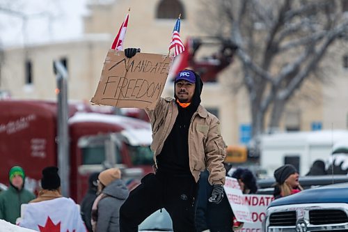 Daniel Crump / Winnipeg Free Press. A man holds a sign as the trucker convoy protest at the Manitoba legislature continues Saturday in Winnipeg. February 5, 2022.