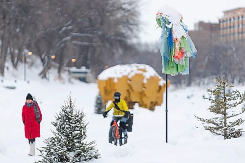 Daniel Crump / Winnipeg Free Press. People walk by a windsock on the Nestaweya river trail on the Assiniboine river Saturday afternoon. The windsock is an art installation titled Come Fly with Me and is part of a collection of nine different pieces that has been installed on the trail. February 5, 2022.