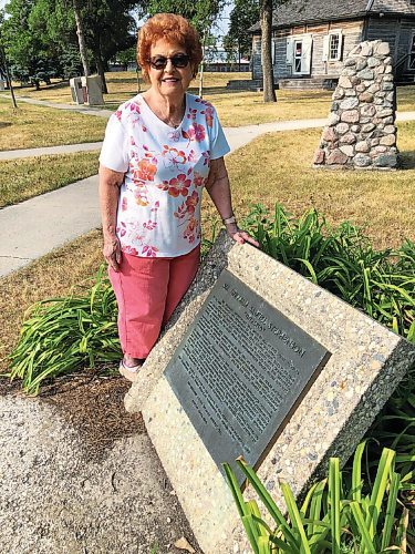 Canstar Community News Correspondent Freda Glow is pictured with this plaque in Joe Zuken Park honoring spymaster Sir William Stephenson. Ross House can be seen in the background.
