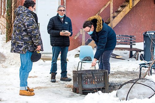 MIKAELA MACKENZIE / WINNIPEG FREE PRESS

Davey Cole (left), George Spence, and Levi Foy put tobacco in the warming fire at Sunshine House in Winnipeg on Tuesday, Feb. 8, 2022. For Eva Wasney story.
Winnipeg Free Press 2022.