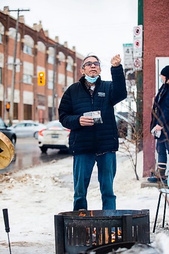 MIKAELA MACKENZIE / WINNIPEG FREE PRESS

George Spence raises tobacco to the warming fire at Sunshine House in Winnipeg on Tuesday, Feb. 8, 2022. For Eva Wasney story.
Winnipeg Free Press 2022.