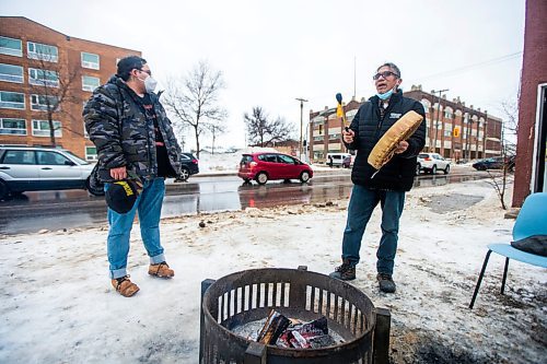 MIKAELA MACKENZIE / WINNIPEG FREE PRESS

George Spence sings and honour song as Davey Cole listens at the warming fire at Sunshine House in Winnipeg on Tuesday, Feb. 8, 2022. For Eva Wasney story.
Winnipeg Free Press 2022.